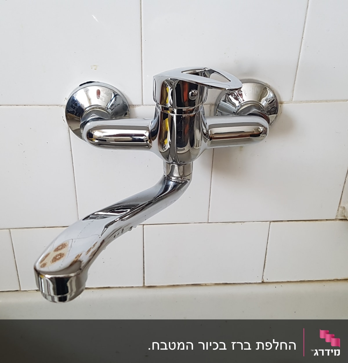 ברז כרום מותקן על קיר אריחים לבנים